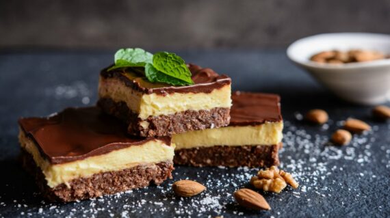 Nanaimo bars - traditional Canadian dessert with wafer crumbs, almond, walnut and cocoa layer, vanilla custard filling and choco
